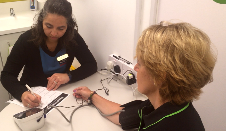 A Pharmacy Locale colleague noting down the results of a blood pressure check