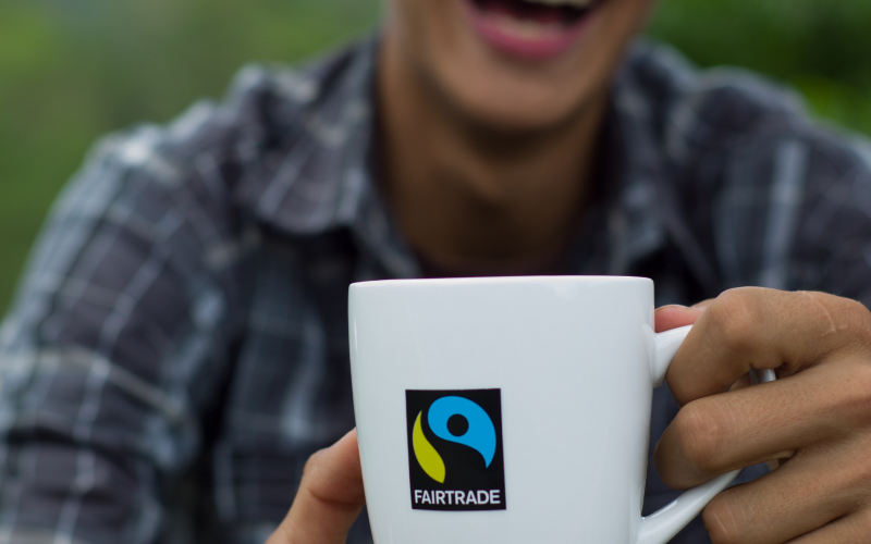 Person holding a mug with a Fairtrade logo on its front